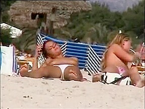 Deux copines topless simulent de baiser sur la plage