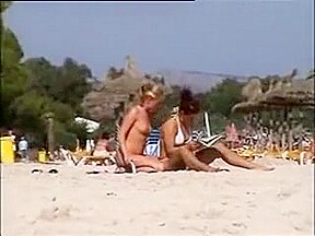 Deux copines topless simulent de baiser sur la plage