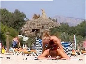 Deux copines topless simulent de baiser sur la plage