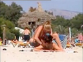 Deux copines topless simulent de baiser sur la plage