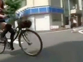 Japanese girl rides a bike with short skirt in streets