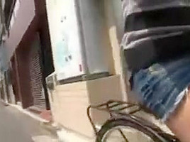 Japanese girl rides a bike with short skirt in streets