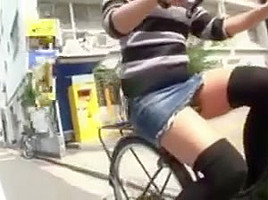 Japanese girl rides a bike with short skirt in streets