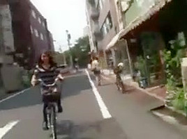 Japanese girl rides a bike with short skirt in streets