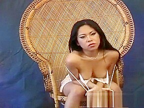 Miki Chan poses on and by her wicker chair showing nice skin