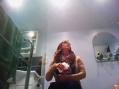 Sexy milf looking around when pissing on the toilet