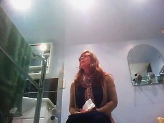 Sexy milf looking around when pissing on the toilet