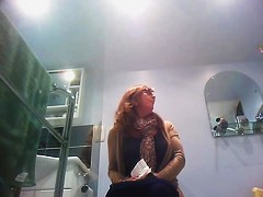 Sexy milf looking around when pissing on the toilet