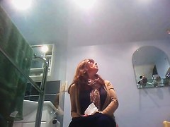Sexy milf looking around when pissing on the toilet