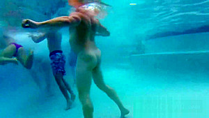 Swinger couples play slippery melon naked in the swiming pool as a warm up foreplay game