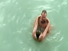 Tattooed nudist fucked in the water