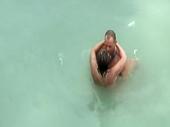 Tattooed nudist fucked in the water