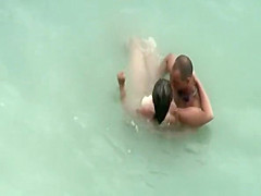 Tattooed nudist fucked in the water