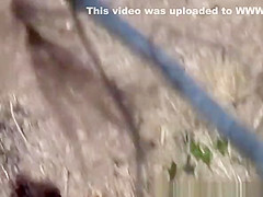 Woman pees next to rock